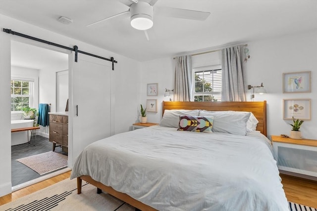 6 Hayes Rd, Salem, MA 01970 - bedroom featuring a barn door, wood finished floors, and a ceiling fan