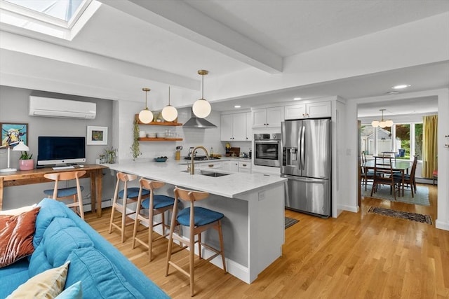 6 Hayes Rd, Salem, MA 01970 - kitchen with appliances with stainless steel finishes, an AC wall unit, a peninsula, open floor plan, and a kitchen bar