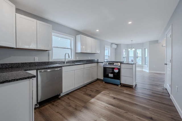 46 Lyons St, Lowell, MA 01852 - kitchen with stainless steel appliances, a sink, a peninsula, white cabinetry, and dark wood-style floors