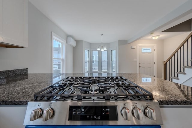 46 Lyons St, Lowell, MA 01852 - kitchen featuring a wall mounted AC, a chandelier, dark stone countertops, and white cabinetry