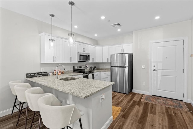 kitchen with visible vents, a peninsula, baseboards, a sink, and stainless steel appliances