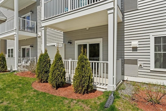 entrance to property with a yard and a balcony
