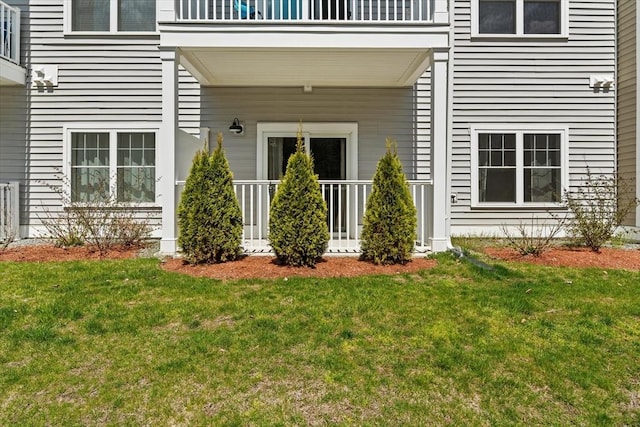 property entrance with a yard, a balcony, and a porch