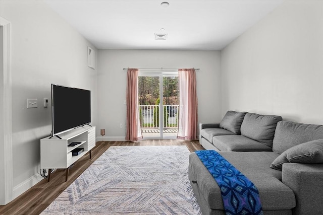 living room with baseboards, wood finished floors, and visible vents