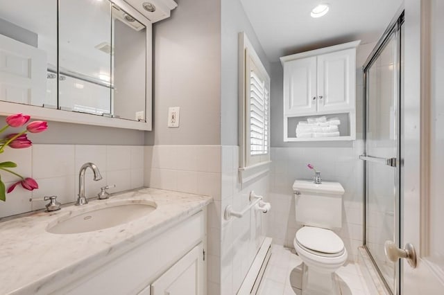 bathroom with vanity, a shower with door, toilet, and tile walls