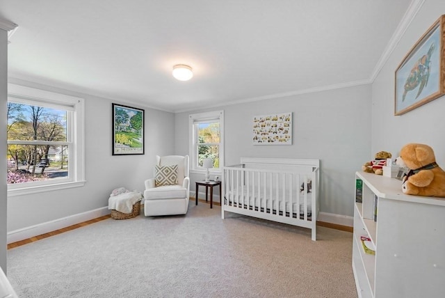 bedroom with crown molding, baseboards, and a crib