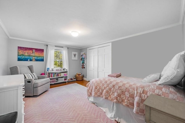 bedroom featuring crown molding, baseboards, wood finished floors, and a closet