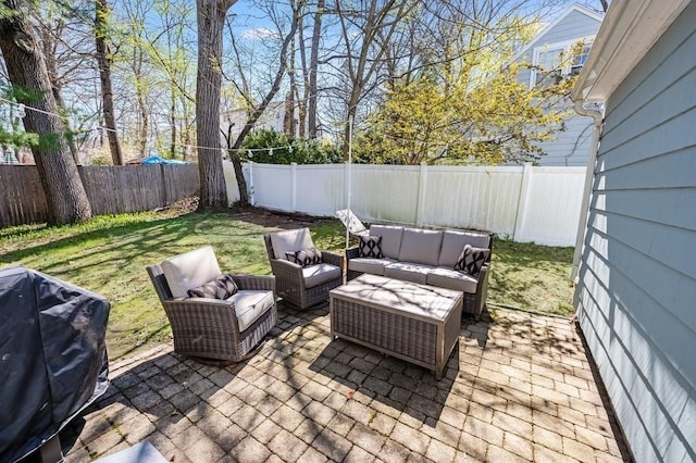 view of patio featuring grilling area, an outdoor living space, and a fenced backyard