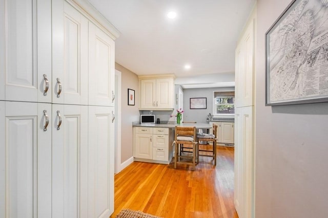kitchen with light countertops, recessed lighting, baseboards, and light wood-style flooring