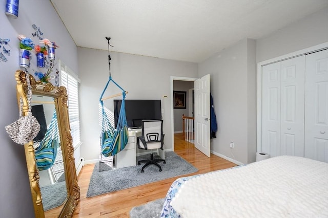 bedroom featuring wood finished floors, a closet, and baseboards