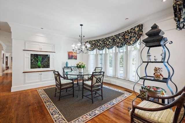 dining space featuring hardwood / wood-style floors, a notable chandelier, and crown molding