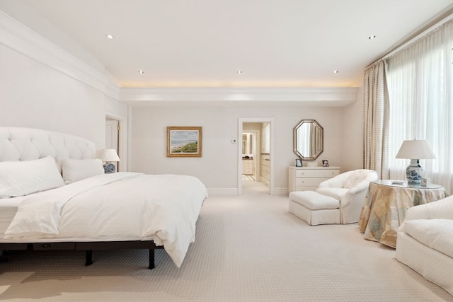 bedroom with light colored carpet and connected bathroom