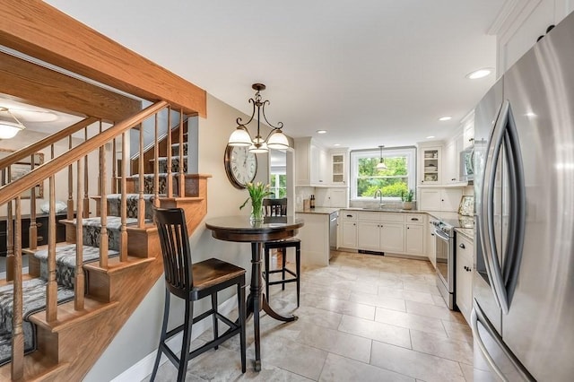 2470 W St, Wrentham, MA 02093 - kitchen with appliances with stainless steel finishes, white cabinets, glass insert cabinets, backsplash, and a sink