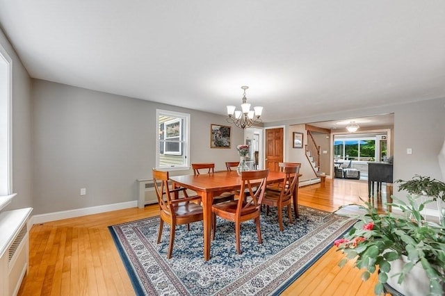 2470 W St, Wrentham, MA 02093 - dining area with stairs, light wood-type flooring, a chandelier, and baseboard heating