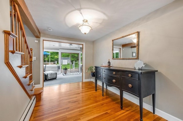 2470 W St, Wrentham, MA 02093 - entrance foyer featuring wood finished floors, stairway, a baseboard heating unit, and baseboards