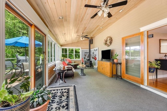 2470 W St, Wrentham, MA 02093 - sunroom featuring ceiling fan, a wood stove, lofted ceiling, plenty of natural light, and wooden walls