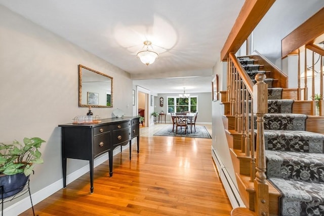 2470 W St, Wrentham, MA 02093 - corridor featuring a chandelier, stairway, light wood-style flooring, a baseboard radiator, and baseboards
