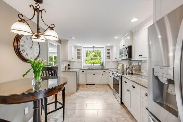 2470 W St, Wrentham, MA 02093 - kitchen with stainless steel appliances, a sink, white cabinets, decorative backsplash, and recessed lighting