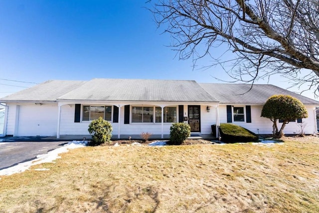 ranch-style house featuring a garage, aphalt driveway, and a front lawn