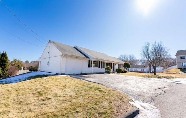 single story home featuring an attached garage, driveway, and a front yard