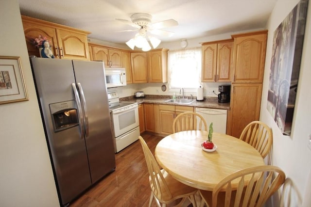 kitchen with light brown cabinetry, white appliances, ceiling fan, dark wood-type flooring, and sink