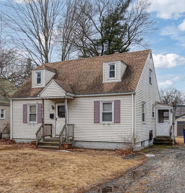 new england style home with roof with shingles