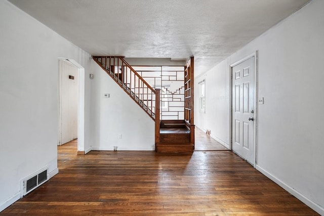 entrance foyer featuring stairs, visible vents, baseboards, and hardwood / wood-style flooring