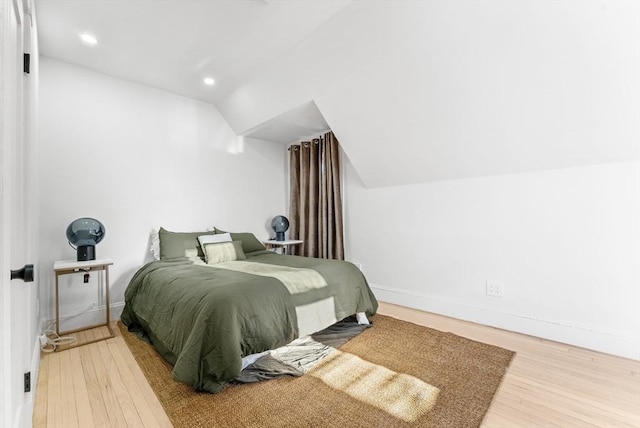 bedroom with lofted ceiling and hardwood / wood-style flooring