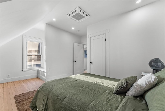 bedroom with hardwood / wood-style floors and vaulted ceiling