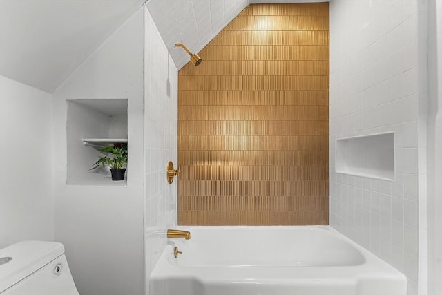 bathroom with toilet, tiled shower / bath combo, and vaulted ceiling