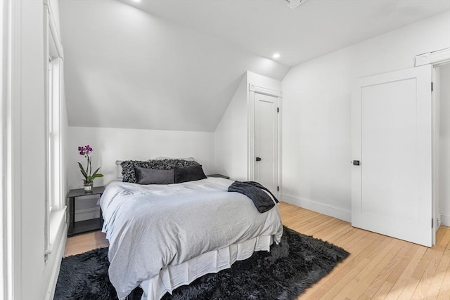 bedroom featuring hardwood / wood-style floors and lofted ceiling