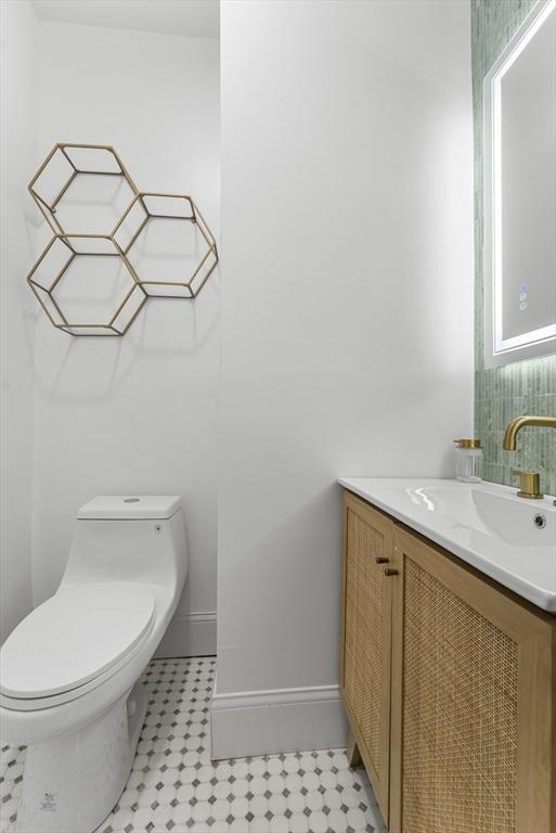 bathroom with tile patterned flooring, vanity, and toilet