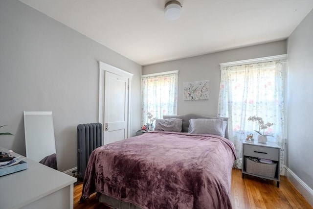 69-71 Pond St, Waltham, MA 02451 - bedroom with radiator, multiple windows, wood finished floors, and baseboards