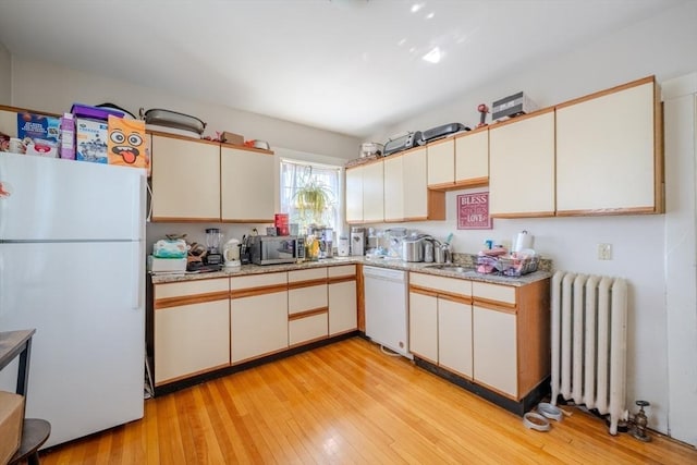 69-71 Pond St, Waltham, MA 02451 - kitchen with white appliances, radiator heating unit, light countertops, and light wood finished floors