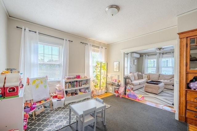 69-71 Pond St, Waltham, MA 02451 - playroom with a textured ceiling, a ceiling fan, wainscoting, an AC wall unit, and wood finished floors