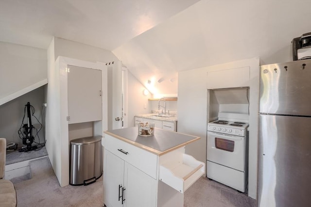 69-71 Pond St, Waltham, MA 02451 - kitchen with freestanding refrigerator, white electric range, a sink, white cabinetry, and light colored carpet