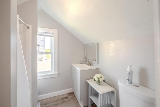 69-71 Pond St, Waltham, MA 02451 - bathroom featuring lofted ceiling, toilet, vanity, wood finished floors, and baseboards