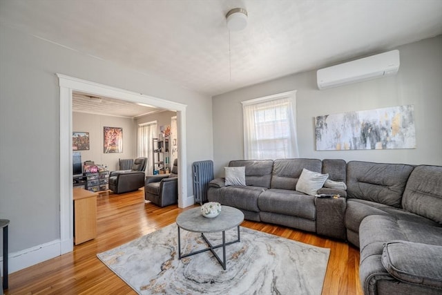 69-71 Pond St, Waltham, MA 02451 - living room with a wall mounted AC, light wood-style flooring, and baseboards