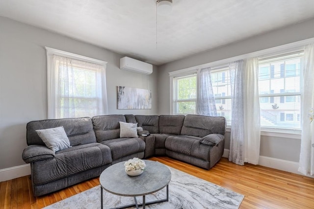 69-71 Pond St, Waltham, MA 02451 - living area with a wall mounted AC, baseboards, and light wood-style flooring