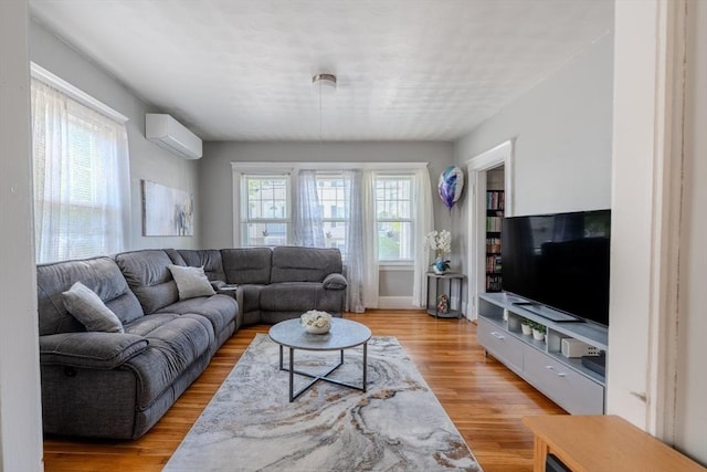 69-71 Pond St, Waltham, MA 02451 - living area featuring a wall mounted AC, light wood-style flooring, and baseboards