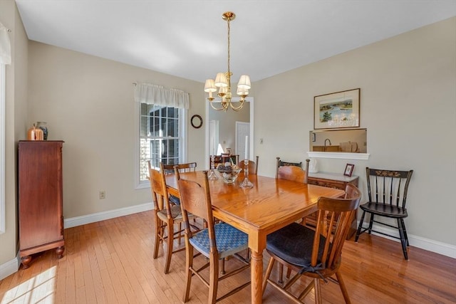 dining room featuring baseboards, a notable chandelier, and light wood-style floors