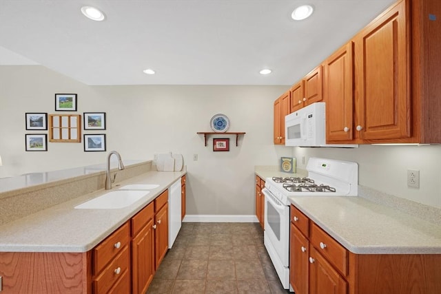 kitchen featuring baseboards, white appliances, a sink, a peninsula, and light countertops