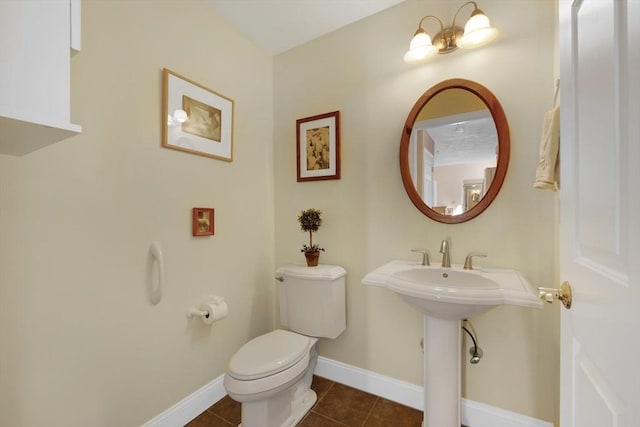 bathroom with tile patterned flooring, toilet, and baseboards