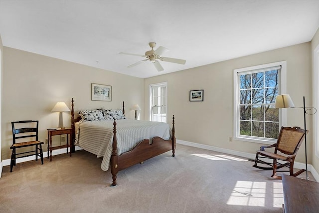 bedroom with light carpet, baseboards, and a ceiling fan