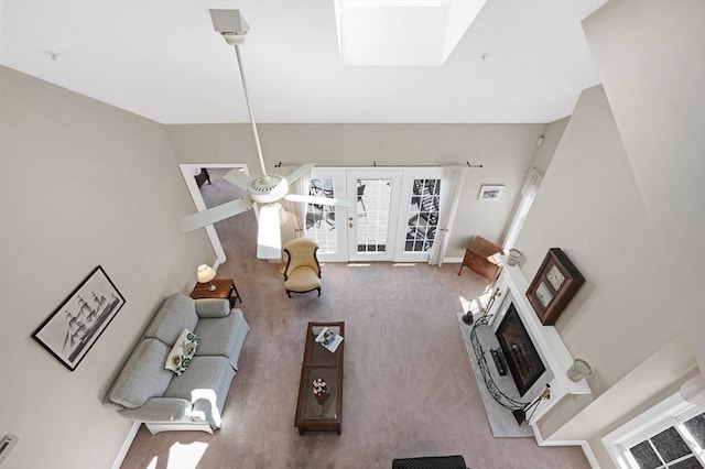 living room with baseboards, carpet flooring, and a skylight