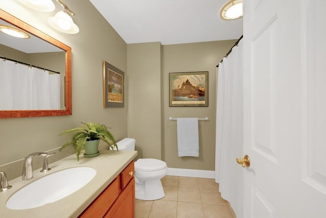bathroom featuring vanity, toilet, baseboards, and tile patterned floors