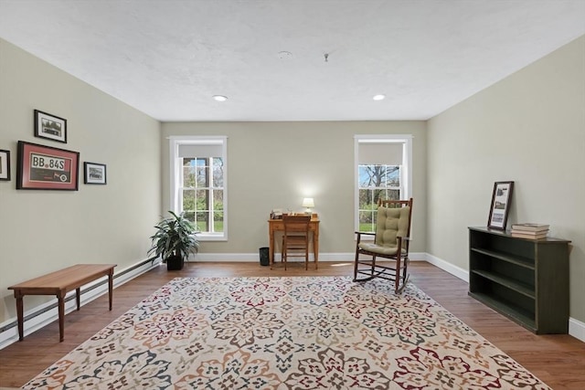 living area featuring recessed lighting, baseboards, baseboard heating, and wood finished floors