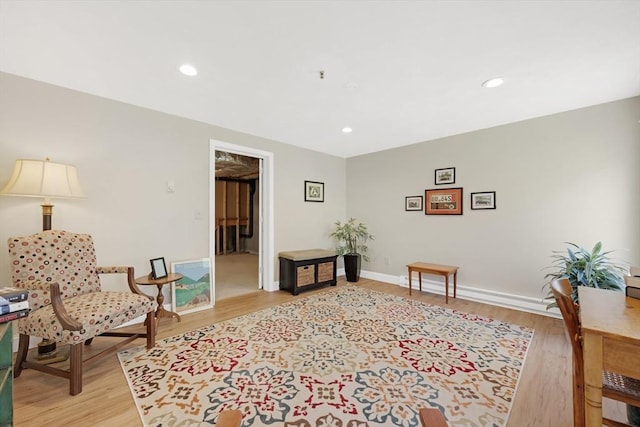 living area with light wood-type flooring, baseboards, and recessed lighting