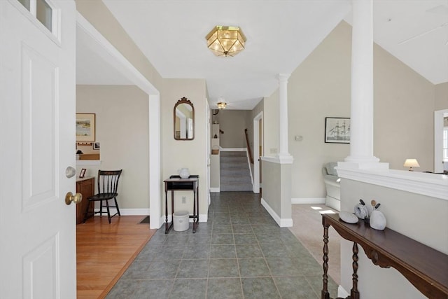 foyer with baseboards, stairs, and decorative columns