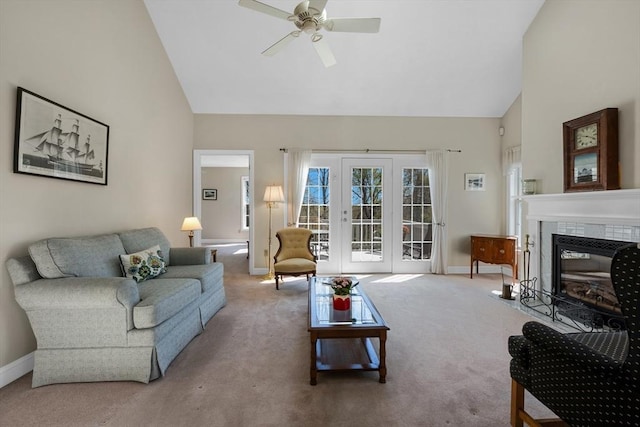 carpeted living room with a ceiling fan, french doors, baseboards, high vaulted ceiling, and a fireplace